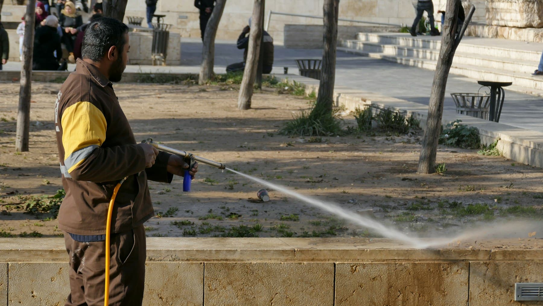 Operator washing down a hard surface