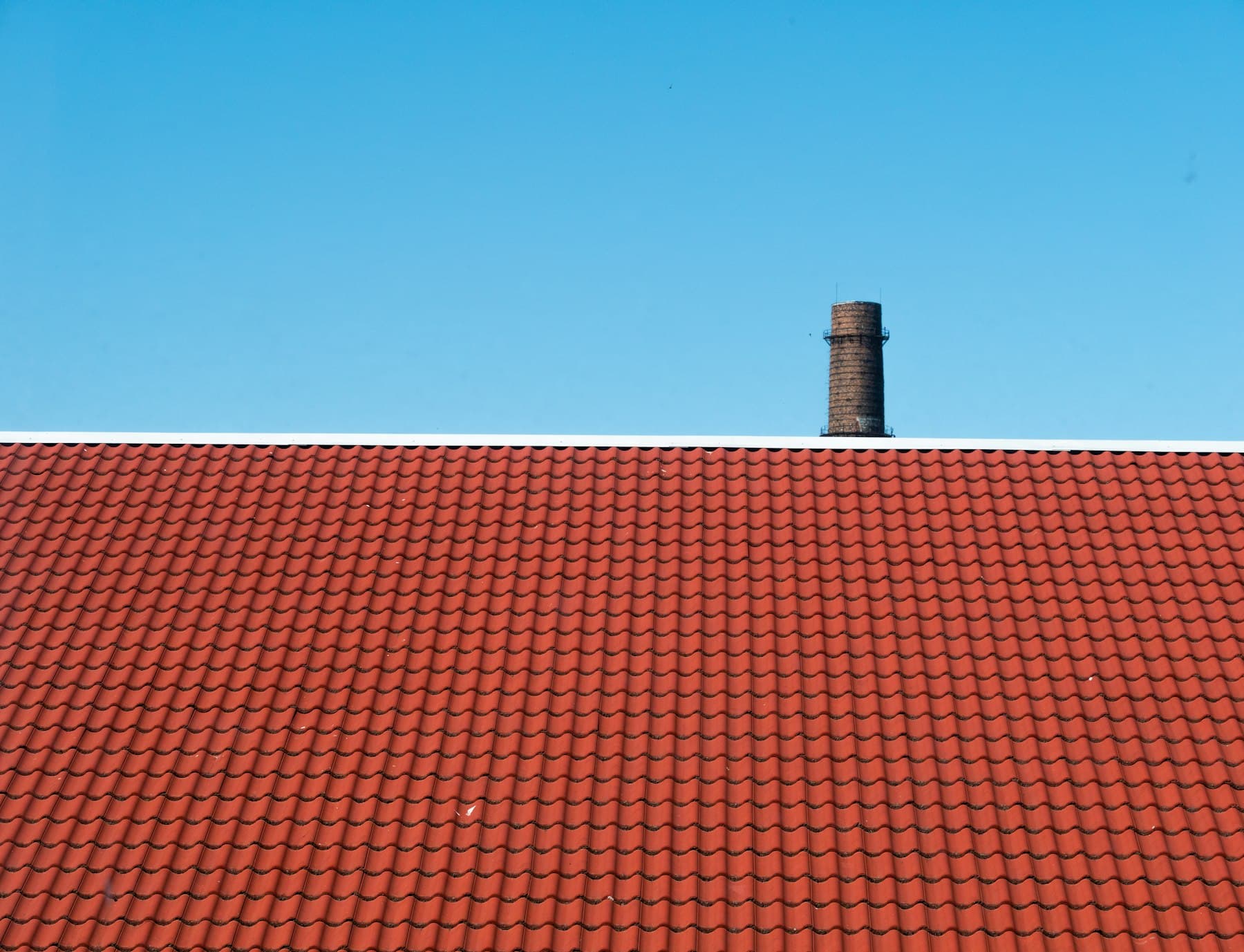 Pitched tiled roof being soft washed